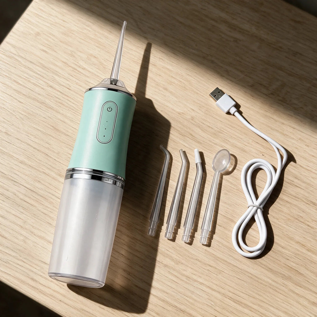 PureStream flosser with four nozzles and USB cable on a wooden table